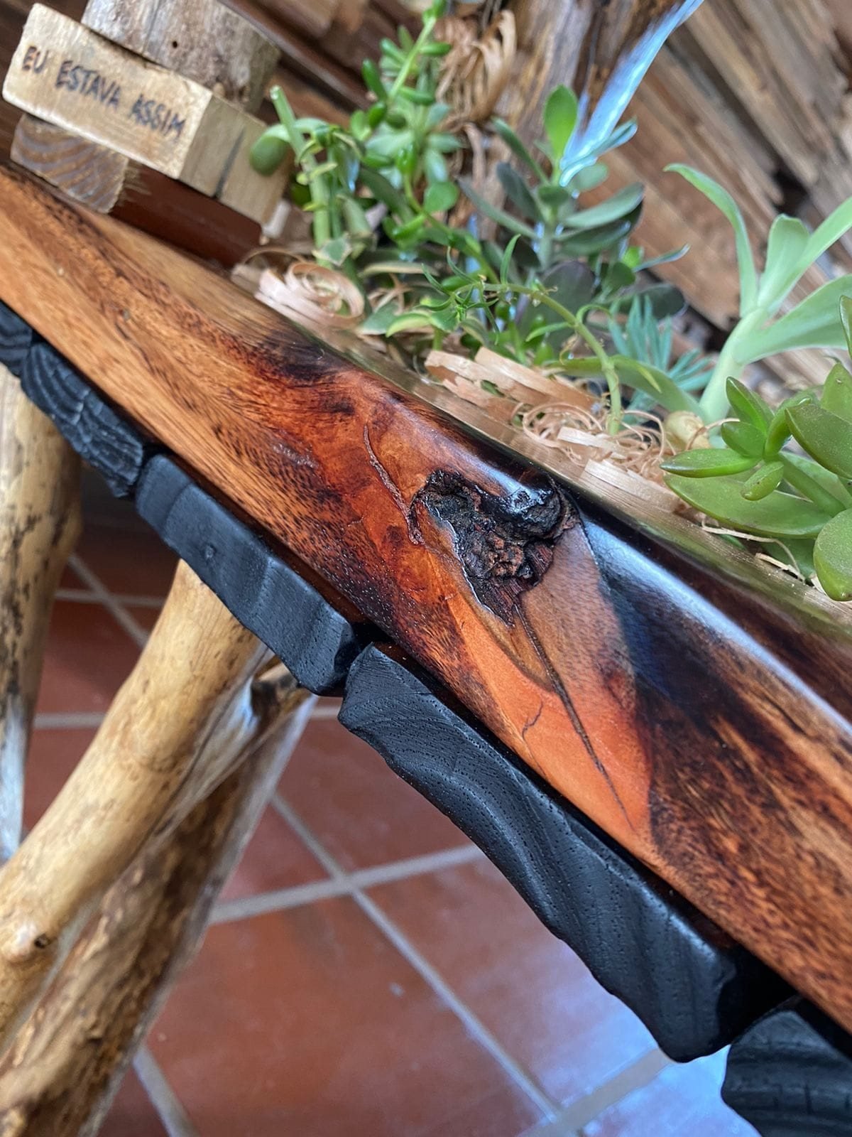 Móvel de madeira de descarte destacando nós naturais e acabamento rústico