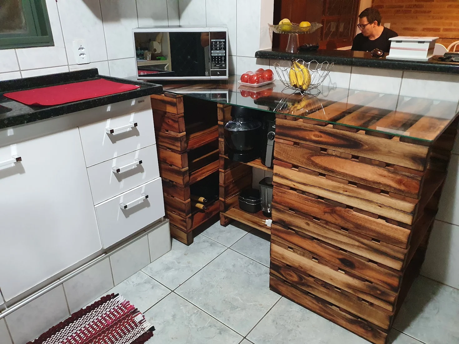 Móvel feito por Felipe Soares Maia: bancada de cozinha de madeira com tampo de vidro e nichos para utensílios